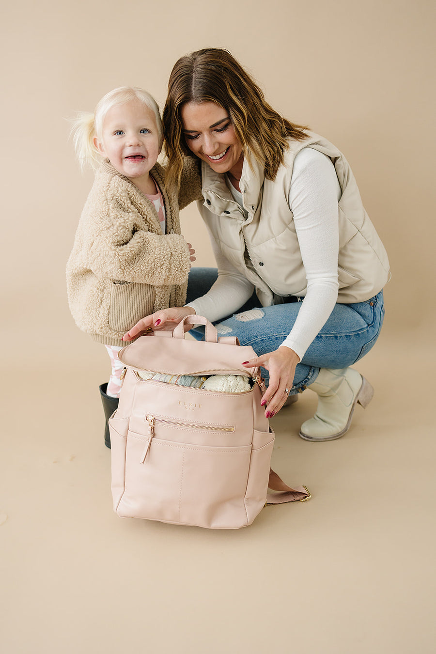 mom and daughter. Mom is closing her Blush capri backpack