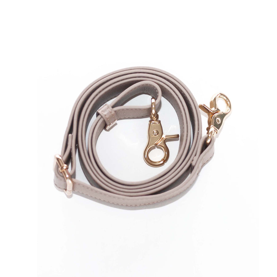 elkie product image with white background. Taupe bag strap rolled up in a circle. 